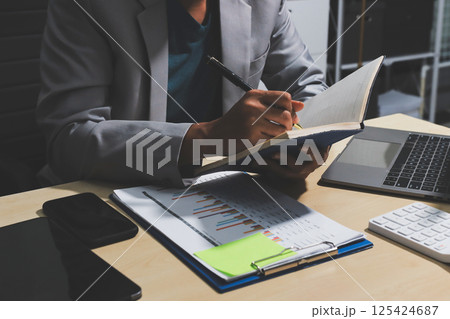 Working from home, Closeup business woman using laptop computer and analyzing financial report. 125424687