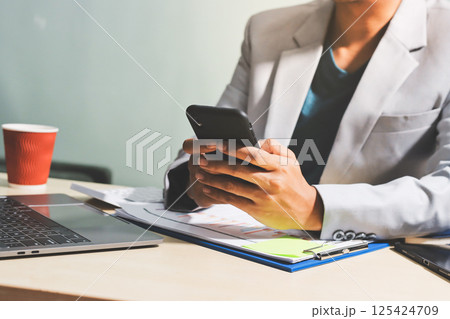 Working from home, Closeup business woman using laptop computer and analyzing financial report. Working from home, Closeup business woman using laptop computer and analyzing financial report. 125424709
