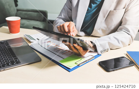 Working from home, Closeup business woman using laptop computer and analyzing financial report. Working from home, Closeup business woman using laptop computer and analyzing financial report. 125424710