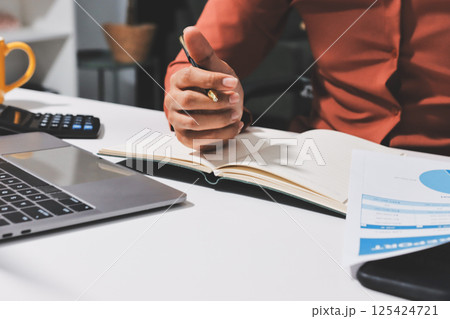 Working from home, Closeup business woman using laptop computer and analyzing financial report. Working from home, Closeup business woman using laptop computer and analyzing financial report. 125424721