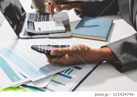 Working from home, Closeup business woman using laptop computer and analyzing financial report. 125424749