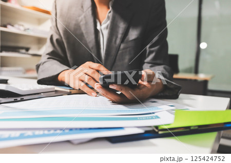 Working from home, Closeup business woman using laptop computer and analyzing financial report. Working from home, Closeup business woman using laptop computer and analyzing financial report. 125424752