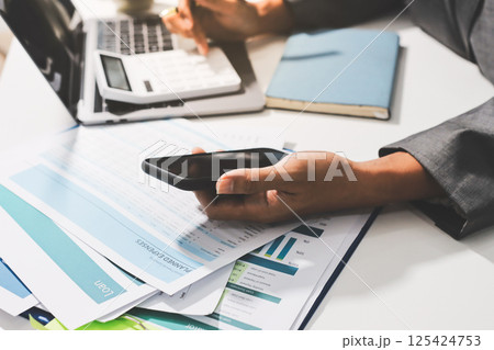 Working from home, Closeup business woman using laptop computer and analyzing financial report. Working from home, Closeup business woman using laptop computer and analyzing financial report. 125424753