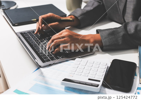 Working from home, Closeup business woman using laptop computer and analyzing financial report. Working from home, Closeup business woman using laptop computer and analyzing financial report. 125424772