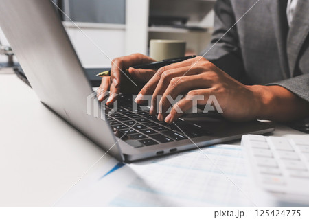 Working from home, Closeup business woman using laptop computer and analyzing financial report. 125424775