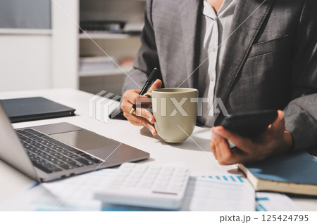 Working from home, Closeup business woman using laptop computer and analyzing financial report. Working from home, Closeup business woman using laptop computer and analyzing financial report. 125424795
