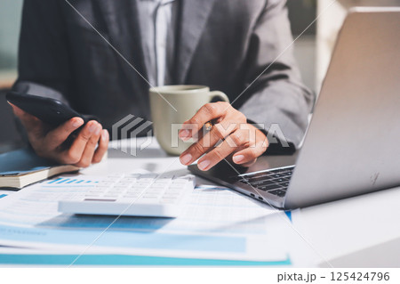 Working from home, Closeup business woman using laptop computer and analyzing financial report. Working from home, Closeup business woman using laptop computer and analyzing financial report. 125424796