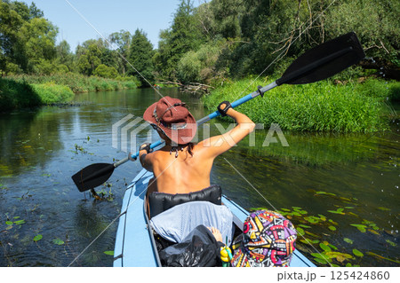 Family kayak trip. Mom and daughter rowing a boat on the river, a water hike, a summer adventure. Eco-friendly and extreme tourism, active and healthy lifestyle Family kayak trip. Mom and daughter rowing a boat on the river, a water hike, a summer adventure. Eco-friendly and extreme tourism, active and healthy lifestyle 125424860