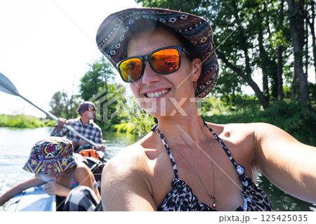 Man and woman couple, child 8 years old, selfies are happy in family kayak trip rowing boat on the river, water hike, a summer adventure. Eco-friendly and extreme tourism, active and healthy lifestyle Man and woman couple, child 8 years old, selfies are happy in family kayak trip rowing boat on the river, water hike, a summer adventure. Eco-friendly and extreme tourism, active and healthy lifestyle 125425035
