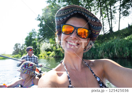 Man and woman couple, child 8 years old, selfies are happy in family kayak trip rowing boat on the river, water hike, a summer adventure. Eco-friendly and extreme tourism, active and healthy lifestyle Man and woman couple, child 8 years old, selfies are happy in family kayak trip rowing boat on the river, water hike, a summer adventure. Eco-friendly and extreme tourism, active and healthy lifestyle 125425036