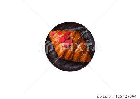 Sweet crispy croissant decorated with red hearts Sweet crispy croissant decorated with red hearts 125425664