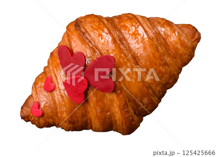 Sweet crispy croissant decorated with red hearts Sweet crispy croissant decorated with red hearts 125425666