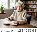 ノートに向き合う高齢女性の静かな時間 125426364