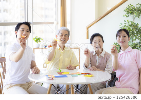 介護イメージ 折り紙を折るシニアと介護士 介護イメージ 折り紙を折るシニアと介護士 125426380