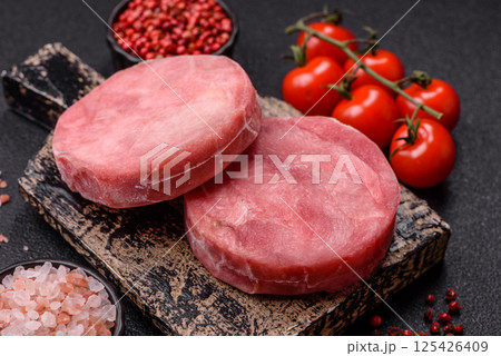 Two fresh slices of raw tuna fillet with spices and herbs Two fresh slices of raw tuna fillet with spices and herbs 125426409