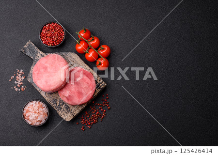 Two fresh slices of raw tuna fillet with spices and herbs Two fresh slices of raw tuna fillet with spices and herbs 125426414