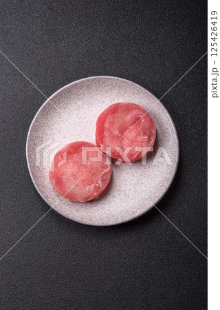 Two fresh slices of raw tuna fillet with spices and herbs 125426419