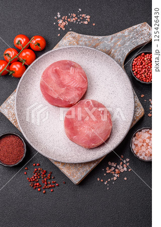 Two fresh slices of raw tuna fillet with spices and herbs 125426430