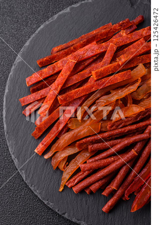 Jerky, dried fish in the form of sticks with salt, spices and herbs 125426472