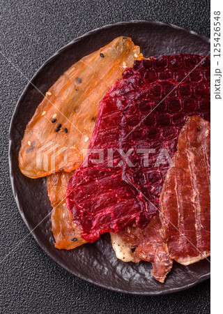 Jerky, dried meat in the form of slices with salt, spices and herbs 125426548