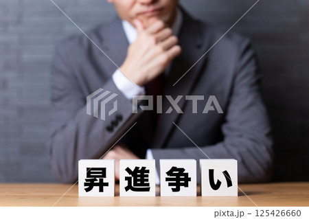 昇進争いのブロックとスーツを着て悩むミドル男性ビジネスマン 125426660