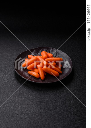 Raw peeled mini baby carrots as an ingredient for preparing a vegetarian food 125426665