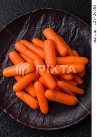 Raw peeled mini baby carrots as an ingredient for preparing a vegetarian food 125426668
