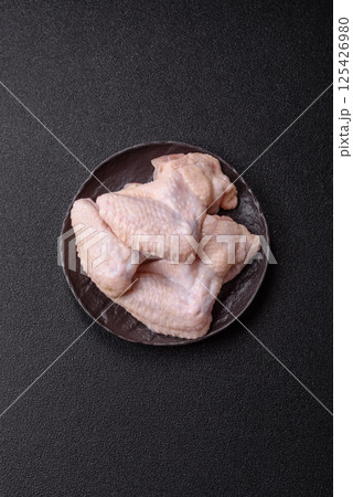 Raw chicken wings with salt, spices and herbs Raw chicken wings with salt, spices and herbs 125426980