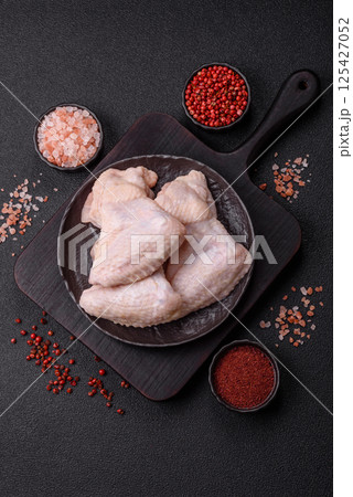 Raw chicken wings with salt, spices and herbs Raw chicken wings with salt, spices and herbs 125427052