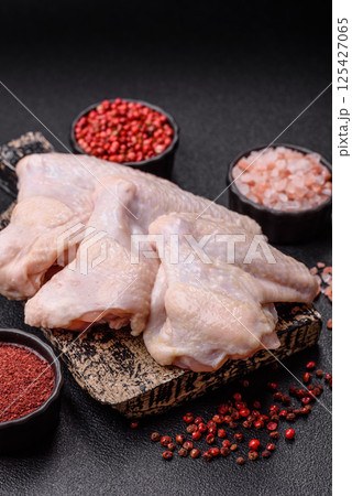 Raw chicken wings with salt, spices and herbs Raw chicken wings with salt, spices and herbs 125427065