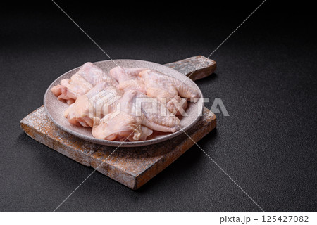 Raw chicken wings with salt, spices and herbs Raw chicken wings with salt, spices and herbs 125427082