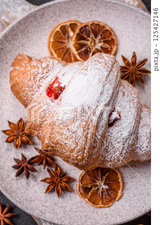 Sweet fresh crispy croissant with fruit filling 125427146
