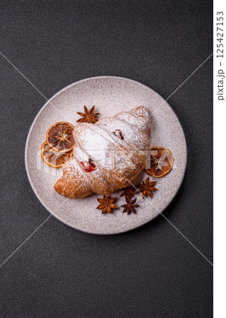 Sweet fresh crispy croissant with fruit filling 125427153