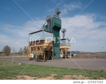 A large grain storage facility featuring tall silos and wellorganized operations set against a clear blue sky A large grain storage facility featuring tall silos and wellorganized operations set against a clear blue sky 125427202