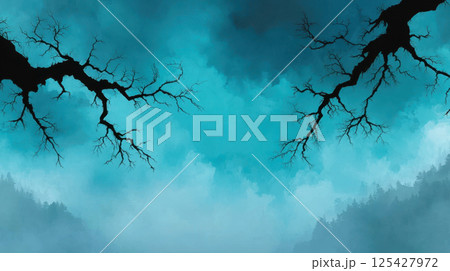 Silhouette of tree branches against misty blue sky creates mysterious atmosphere 125427972