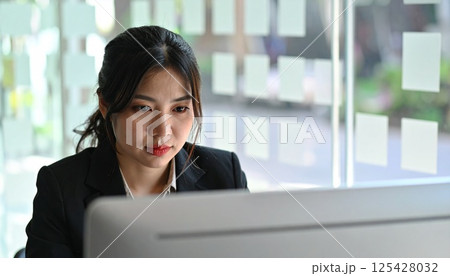 オフィスで力強く働く女性の表情 125428032