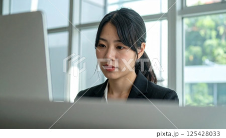 オフィスで力強く働く女性の表情 125428033