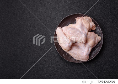 Raw chicken wings with salt, spices and herbs Raw chicken wings with salt, spices and herbs 125428239