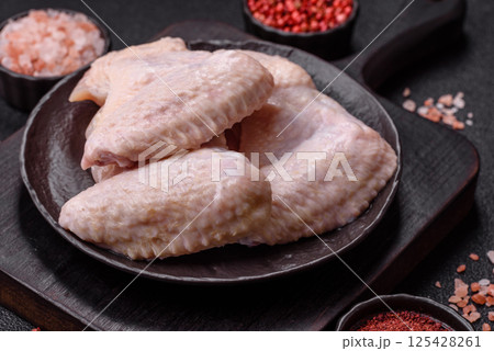 Raw chicken wings with salt, spices and herbs 125428261