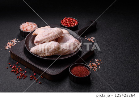 Raw chicken wings with salt, spices and herbs Raw chicken wings with salt, spices and herbs 125428264