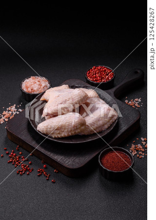 Raw chicken wings with salt, spices and herbs Raw chicken wings with salt, spices and herbs 125428267