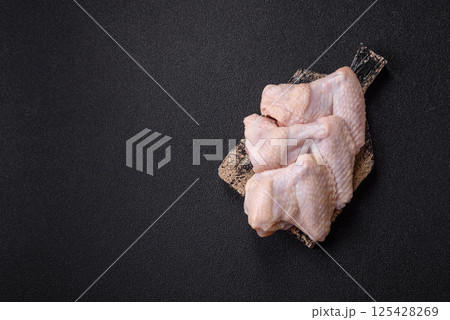Raw chicken wings with salt, spices and herbs Raw chicken wings with salt, spices and herbs 125428269