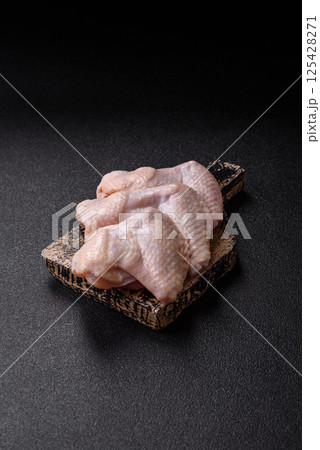 Raw chicken wings with salt, spices and herbs Raw chicken wings with salt, spices and herbs 125428271