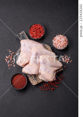 Raw chicken wings with salt, spices and herbs Raw chicken wings with salt, spices and herbs 125428282