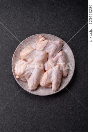 Raw chicken wings with salt, spices and herbs Raw chicken wings with salt, spices and herbs 125428286