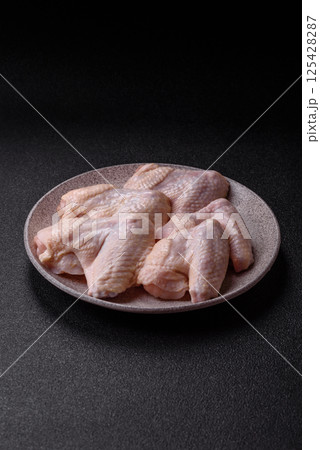 Raw chicken wings with salt, spices and herbs 125428287