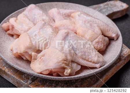 Raw chicken wings with salt, spices and herbs 125428292