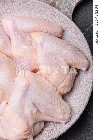 Raw chicken wings with salt, spices and herbs Raw chicken wings with salt, spices and herbs 125428294