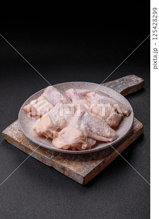 Raw chicken wings with salt, spices and herbs Raw chicken wings with salt, spices and herbs 125428299
