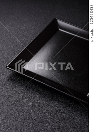 Empty ceramic round plate on dark textured concrete background Empty ceramic round plate on dark textured concrete background 125428458